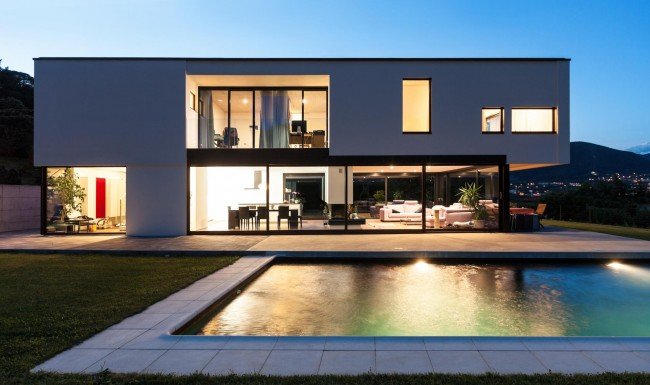 Modern two-story custom home with pool at dusk