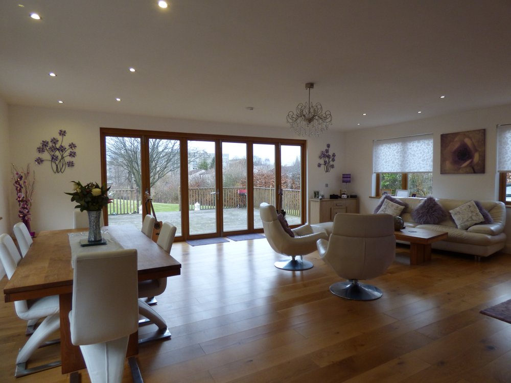 Open living room with wide bi-fold doors and hardwood flooring