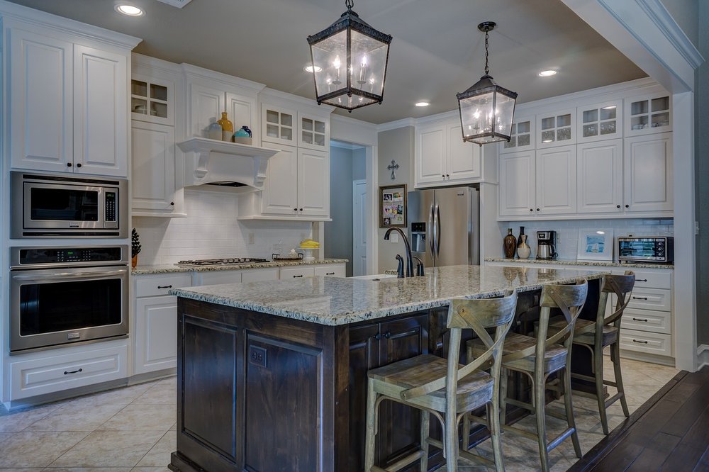 White kitchen with large island and lantern pendants