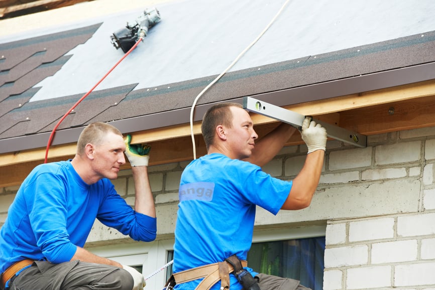 Crew installing new roofing on a home